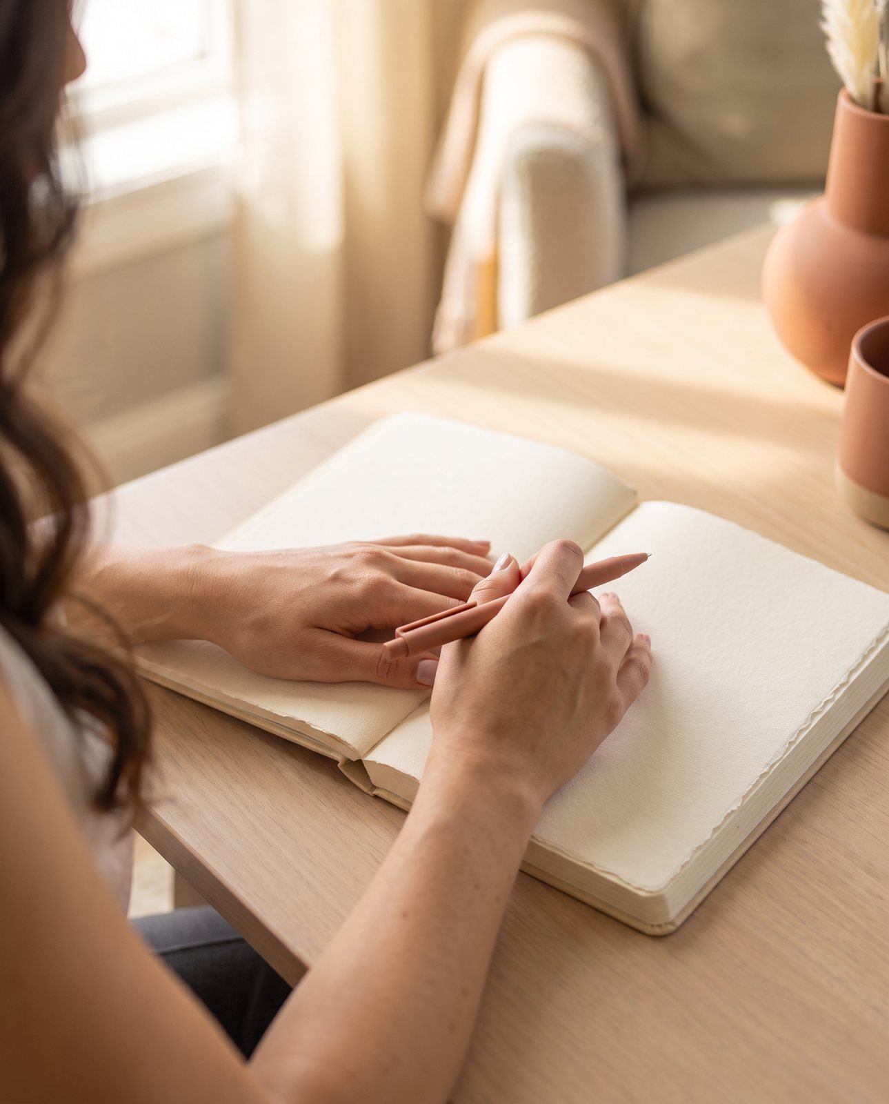 Mãos escrevendo em um caderno, momento de reflexão e escuta